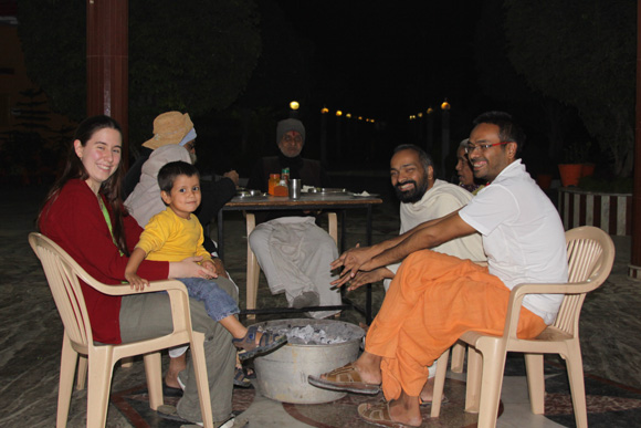 Swami Ji and his family sitting around the fire